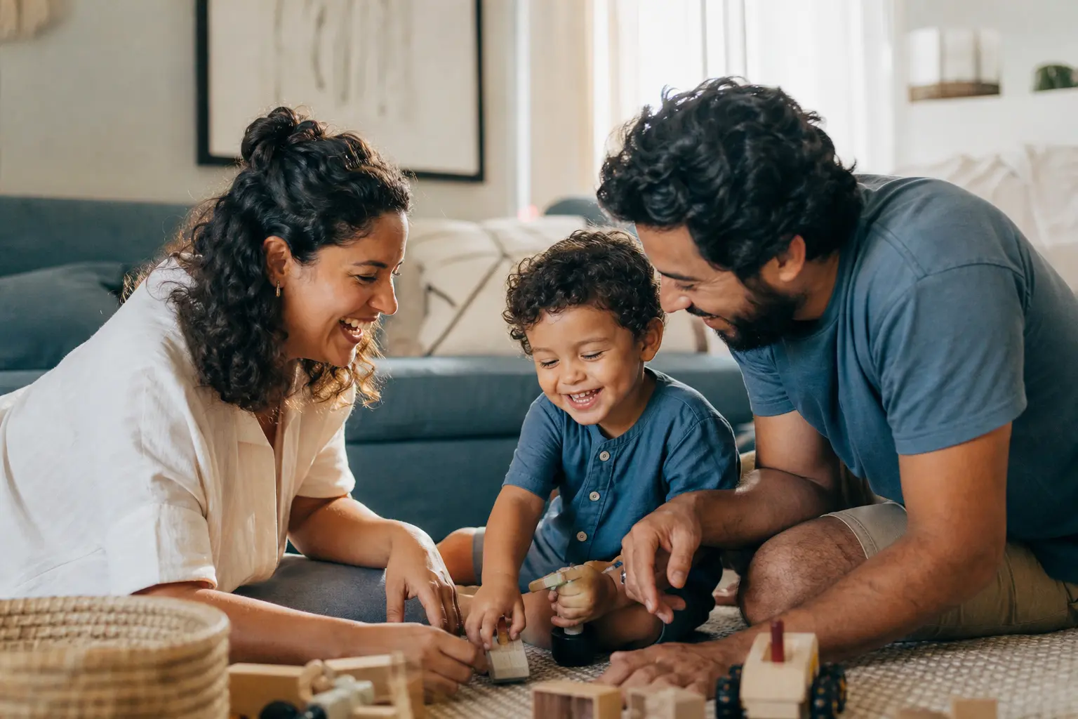 Família brincando com uma criança pequena na sala de casa